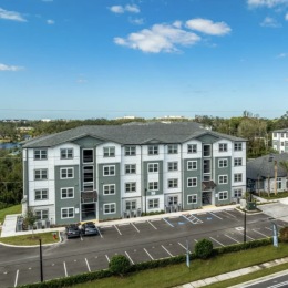 exterior of building with green turf and some seating